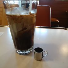 加糖済みのアイスコーヒーに、ステンレスのミルクピッチャー