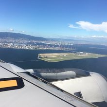 手前の緑の平たい島が神戸空港島