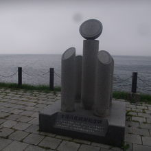 海沿いに建つ起登臼の日食観測記念碑の様子