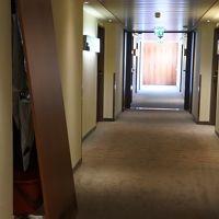 廊下は明るいけれど、壁板が外されて配管がみえていた。