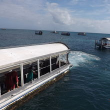 グラスボトムボートはクルーズ船の到着した桟橋付近で漂います