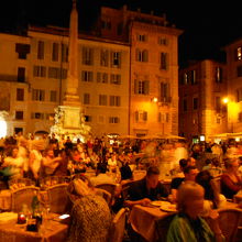 夜の広場で食事する人々