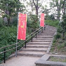 六文銭の赤い幟が立つ石段を登って山頂(標高26M)へ