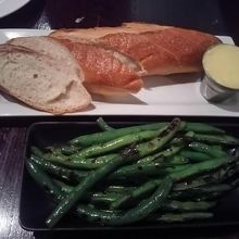 フランスパンが添えられた ｢エンドウ豆のオイル炒め｣