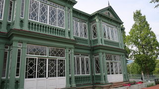 幾何学模様の綺麗な窓枠と、薄緑に塗られた外壁