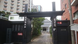 黒い角材組み山門と土蔵造りの本堂