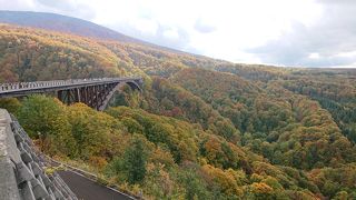 雄大な山の紅葉に架かる橋