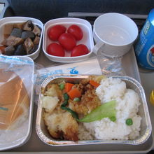 機内食です。付け合わせの煮物、トマトとか。。。