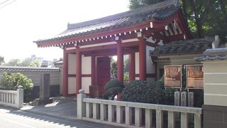 朱塗りの柱と白壁の山門や都指定旧跡の墓などがある寺院です