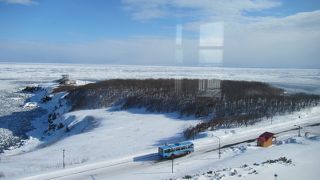 車窓に流氷を眺めるバス