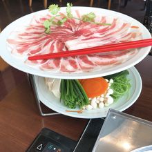 黒豚の上にスライス生ニンニクが3枚細長ネギパクチーが載る