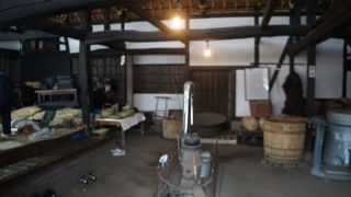 座敷では何人かの地元の人が竹細工を編んでいて