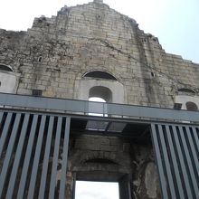 下をくぐった裏手、階段を降りたところにあります。