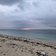 雲が垂れ込め、かすかに赤いのが朝日の場所