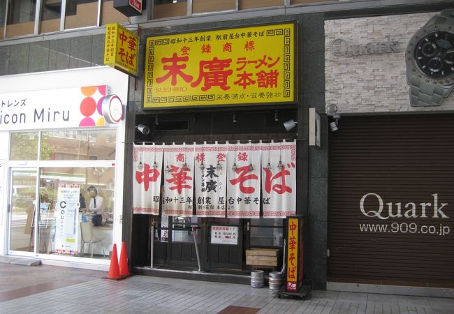 アーケード商店街の赤い入口のラーメン店