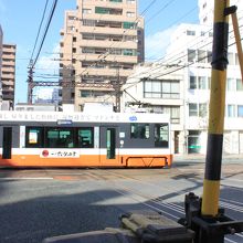郊外線の踏切を路面電車が渡ってゆく