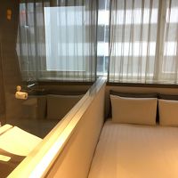 ベッドと洗面所。ガラス張りなので、トイレから客室が見える