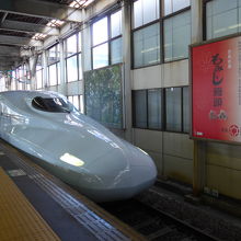 乗車する新大阪行きの新幹線と名物もみじ饅頭の看板
