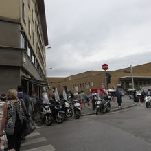 写真の右SMN駅でバイクの向こうがトラム駅・左手の建物です