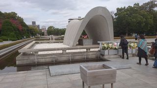 慰霊碑の前で拝む人がいます。