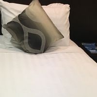 清潔感のあるベッド。脇にソファとテーブル有