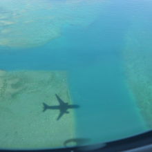 飛行機の影が海に映って