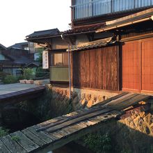 朝日に輝く川沿いの裏木戸