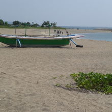 海岸の砂浜の中央には、漁船らしきカヌーが置かれています。