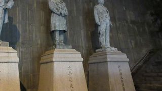 燕尾服を来た温厚なお顔の像です。