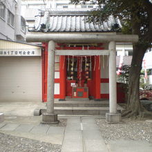 津軽稲荷神社の社殿です。赤色基調です。手前に鳥居があります。