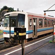 五十猛駅駅名標と離合するキハ120系出雲市行き普通列車、