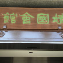 参拝者無料休憩所の標識のある休憩所の建物の入口上部の額です。