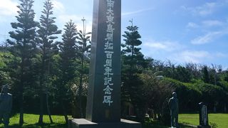 海を見つめる銅像とともに建つ