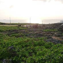 海に反射する夕日と灯台
