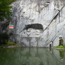 池の向こう側の岩場に記念碑があります