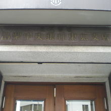 山梨中央銀行東京支店の玄関入口の上部には、標識があります。