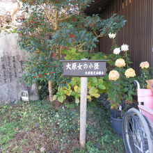 「大原女の小道」の立札が立ち、奥に「女ひとり」の歌碑が静かに