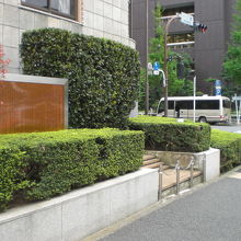 我が国の大学発祥の地の解説板は、学士会館の植え込みの中にあり