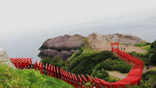 日本海の青を背景に多数の赤い鳥居が並ぶ