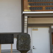 新派の碑の背後にある天満宮の宝物殿の建物の一部が映っています