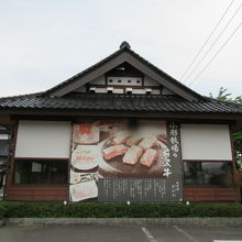 道路に面した店の外観。向かいにはイオンが
