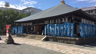 本堂の前で風にたなびく鮮やかな青いのぼり