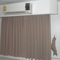 客室内のカーテンとエアコンです。壁の白色とマッチしている感じ