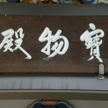 湯島天満宮の宝物殿の入り口の上部の額です。白色の文字です。