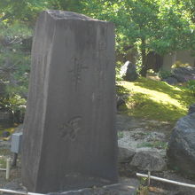 緑の樹々の中に置かれている筆塚の岩の碑です。重みがあます。