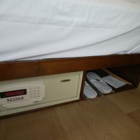 ベッド下に使い捨てスリッパと金庫がある