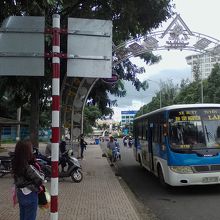 ブオンジュン行きのバスとバス停。奥に見えるのが戦勝記念碑。