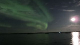 湖に満月が反射し空にはレベル4のオーロラ