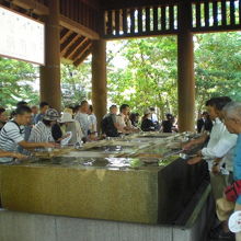 神門の手前の南側には、手水の水舎があります。沢山の参拝客です