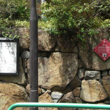 文人通りの歩道の石垣に付けられた居住跡の赤色の標識です。